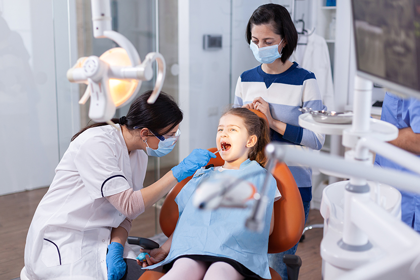 Child receiving dental care in a friendly and comfortable clinic environment.